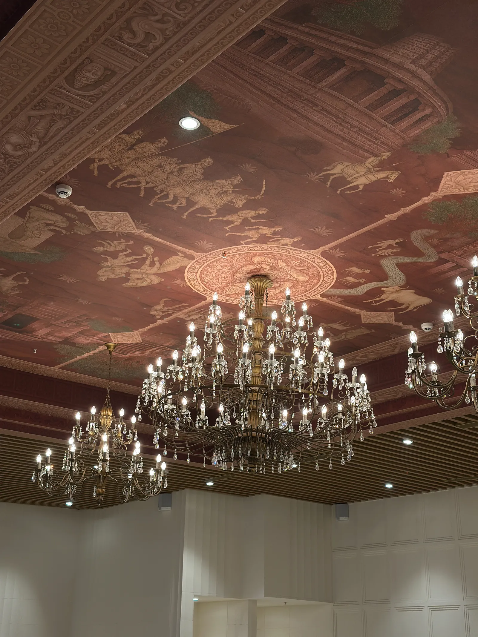 Crystal chandeliers under a hand-painted ceiling — Chalukya Samrat